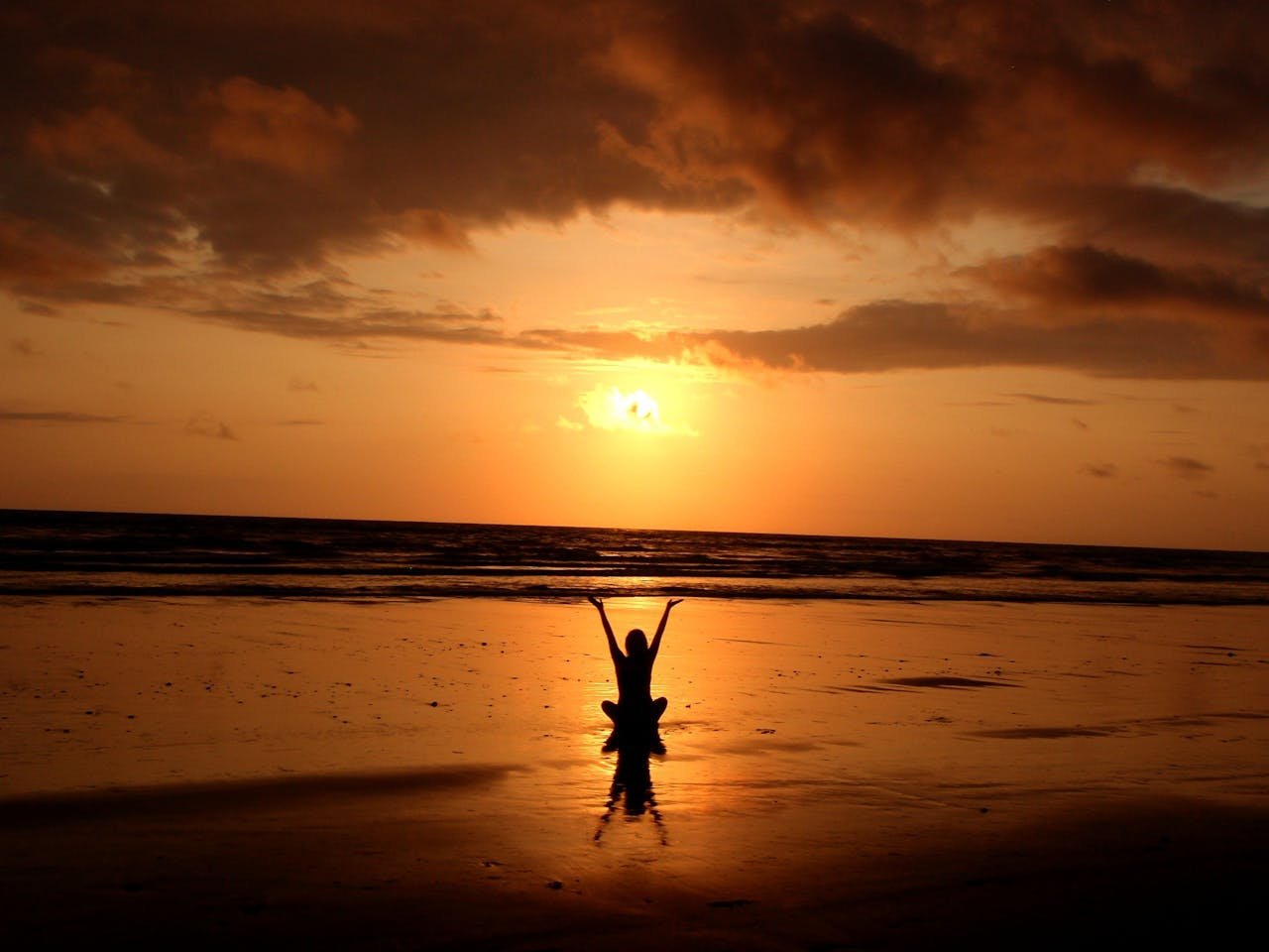 about-us-02 Peaceful meditation silhouette at sunset on a serene beach.